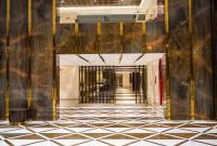 Un pasillo con suelo de baldosas blancas y negras. en UVA MANISH, en Kundapur