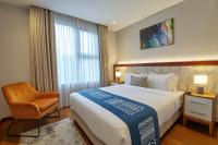 a bedroom with a large bed and a chair at Deerpark Luxury Stays in Nairobi