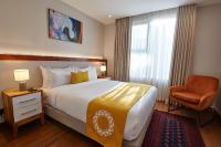 a hotel room with a large bed and a chair at Deerpark Luxury Stays in Nairobi