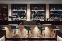 a bar with blue stools in a room at AMERON Hamburg Hotel Speicherstadt in Hamburg