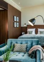 a bedroom with a blue couch and a bed at AMERON Hamburg Hotel Speicherstadt in Hamburg