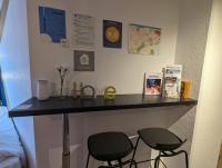 a counter in a room with two stools and a table at Ton Petit Studio - Le 62 - Coeur de Ville in Mulhouse