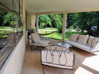 a screened in porch with a couch and chairs at Le Jardin du Dolaizon in Le Puy-en-Velay