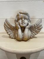 a statue of a baby angel sitting on a table at La Maison Bizienne Guérande in Guérande