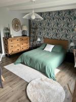 a bedroom with a green bed and a dresser at Ty glaz in Ploubazlanec