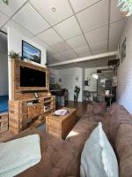 a living room with a couch and a flat screen tv at Studio cosy tout confort - Le Drouvenant in Clairvaux-les-Lacs