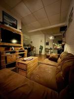 a living room with a couch and a flat screen tv at Studio cosy tout confort - Le Drouvenant in Clairvaux-les-Lacs