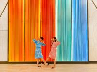 two women walking in front of a colorful wall at Uni-Resort Ku-Kuan in Heping