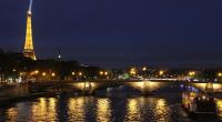 a bridge over a river at night with the eiffel tower at Chic apart with parking and balcony near Paris in Aubervilliers