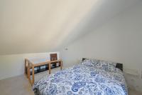 a bedroom with a bed with a blue and white comforter at La Cigale - Vieux Village - Charmante Maisonnette climatisée avec Jardin in Villeneuve-lès-Avignon