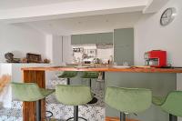 a kitchen with green bar stools at a counter at La Cigale - Vieux Village - Charmante Maisonnette climatisée avec Jardin in Villeneuve-lès-Avignon