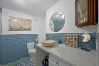 a bathroom with a sink and a toilet and a mirror at La Cigale - Vieux Village - Charmante Maisonnette climatisée avec Jardin in Villeneuve-lès-Avignon