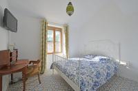 a bedroom with a bed and a desk and a television at La Cigale - Vieux Village - Charmante Maisonnette climatisée avec Jardin in Villeneuve-lès-Avignon