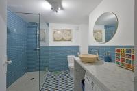 a bathroom with blue tiles and a glass shower at La Cigale - Vieux Village - Charmante Maisonnette climatisée avec Jardin in Villeneuve-lès-Avignon