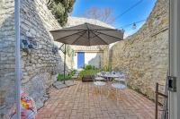 a patio with a table and an umbrella at La Cigale - Vieux Village - Charmante Maisonnette climatisée avec Jardin in Villeneuve-lès-Avignon