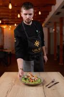 um homem segurando um prato de comida em uma mesa em Orava Village em Oravská Lesná