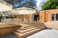 un patio con scale, tavoli e ombrelloni di Apartamenty Leśna Przystań 2 a Węgorzewo