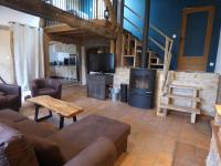 a living room with a couch and a tv at L’ESPRIT JANADE – GITE 4 A 6 PERSONNES. in Fénols
