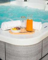 a tray of food and a glass of orange juice next to a swimming pool at T2 jacuzzis et piscine au centre ville de Port-Louis in Port-Louis