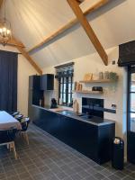 a kitchen with black cabinets and a table in it at Gastenverblijf A&amp;A met mezzanine in Gavere