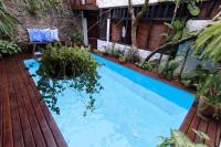 a swimming pool in the middle of a garden at Pousada Arte Urquijo in Paraty