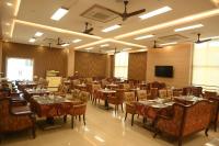 Mayfair World Cup Village في Rourkela: قاعة احتفالات مع طاولات وكراسي وتلفزيون