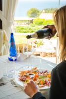 uma mulher sentada à mesa com um copo de vinho em PedrAmare Suite em Alghero