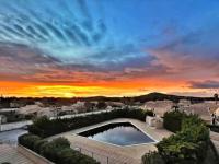 a sunset over a city with a swimming pool at Studio 317, Port Vénus au village naturiste in Cap d&#39;Agde