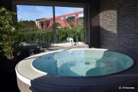 a bath tub with a view of a bridge at Logis Hôtel Beau Site in Loubaresse