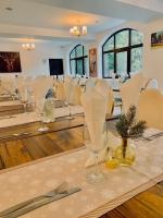 a dining room with a table with chairs and wine glasses at Cerbul Chalét Accommodation & Wellness in Râşnov