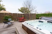 a hot tub on a deck with a table and chairs at L&#39;Orinss - Maison avec jacuzzi in Saint-Orens-de-Gameville