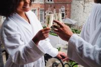 two people holding up glasses of champagne at Van Der Valk Sélys Liège Hotel &amp; Spa in Liège