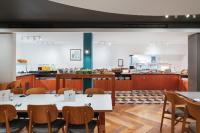 a kitchen and dining room with tables and chairs at Holiday Inn Northampton by IHG in Northampton