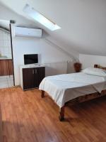 a white bedroom with a bed and a television at Vila Gherghisan in Valu lui Traian