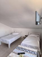 two beds in a room with a table and a tv at Vila Gherghisan in Valu lui Traian