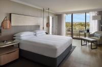 a bedroom with a large white bed and a balcony at Orlando World Center Marriott in Orlando