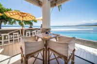 un tavolo e sedie su una veranda con vista sull'oceano di Bombora Medewi a Pulukan