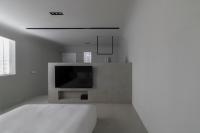 a white bedroom with a bed and a flat screen tv at 山久蒔x勺光 in Yuchi