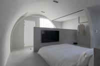 a white bedroom with a large bed and a flat screen tv at 山久蒔x勺光 in Yuchi