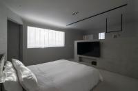 a bedroom with a white bed and a flat screen tv at 山久蒔x勺光 in Yuchi