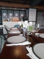 a long table with plates and wine glasses on it at BH Baan Paradise Hotel Patong in Patong Beach