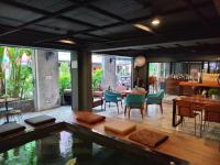a restaurant with a pool in the middle of a room at BH Baan Paradise Hotel Patong in Patong Beach