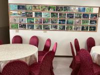 ein Raum mit Tischen und Stühlen und einer Wand mit Bildern in der Unterkunft 星光山悦景觀民宿 in Heping