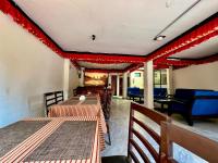 Un restaurante con mesas y sillas y decoraciones rojas. en Taleju Grand Hotel, en Bhaktapur