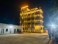 Un edificio alto y amarillo con luces por la noche. en Hotel Janakpur Inn, en Janakpur