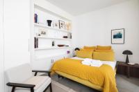 a bedroom with a yellow bed and a chair at Appartement Vertus in Paris