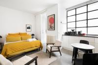 a bedroom with a yellow bed and a table and chairs at Appartement Vertus in Paris