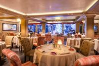 クールシュヴェルにあるLe Lanaの白いテーブルと椅子、テーブルサーチャー付きのレストラン