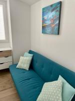 a blue couch in a living room with a painting at Duplex en plein centre in Propriano
