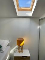 a skylight in a bedroom with a bed and a yellow chair at Duplex en plein centre in Propriano